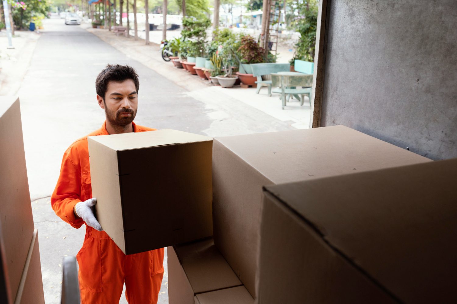 delivery man loading car with delivery boxes