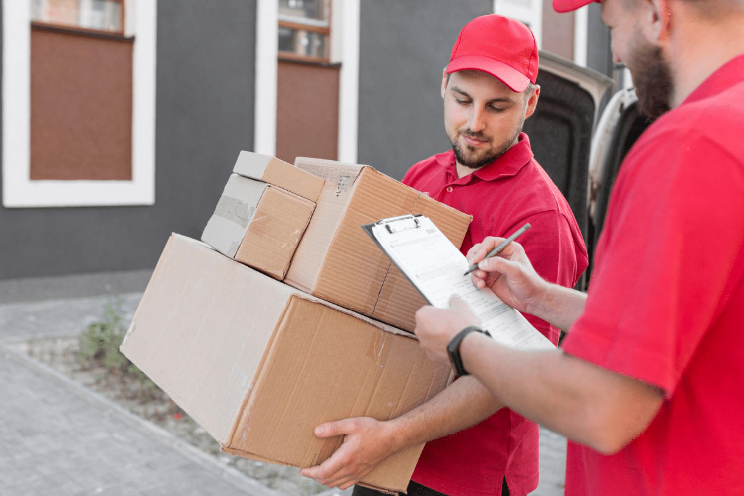 delivery man with packages and other one noting on writing pad